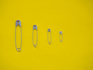 Several safety pins of different sizes. Concept of diversity and inclusion