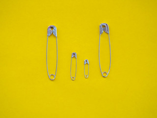 Several safety pins of various sizes in human representation. Concept of traditional family with children