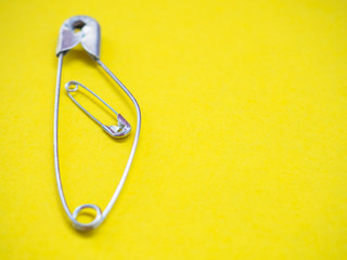 A safety pin representing a pregnant woman with a baby