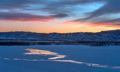 Fototapeta na wymiar Sunset Frozen Lake - Winter sunset view of a frozen mountain lake. Chatfield Reservoir in Chatfield State Park, Denver-Littleton, Colorado, USA.