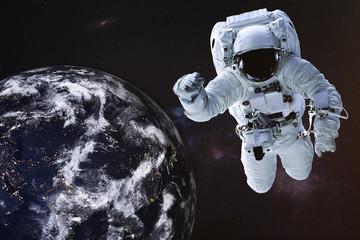 Obraz na płótnie Canvas Astronaut in outer space with Earth planet of solar system. Science fiction wallpaper. Elements of this image were furnished by NASA