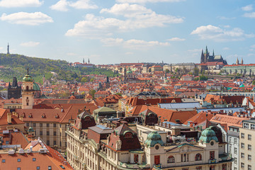 Fototapeta premium Outdoor sunny panoramic aerial scenery of rooftop in old town, city skyline, Charles Bridge tower and background range of mountain with Prague Castle and St. Vitus Cathedral in Prague, Czech Republic.
