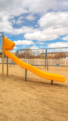 Clear Vertical Playground with slides and swings under the blue sky filled with puffy clouds