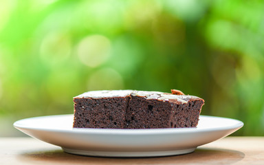 brownies cake on the table / chocolate cake slice with nut on wooden and nature green