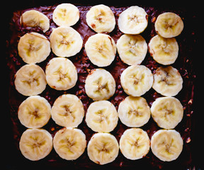 Sliced banana on a cake on a tray before baking it.