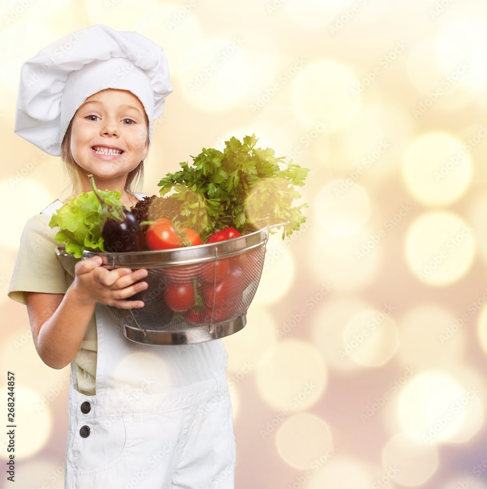 Canvas Prints beautiful little girl in cook hat holding bowl with vegetables