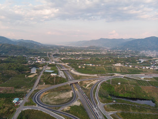 Aerial view of rural expressway with mountains and clouds in the distance