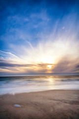 Fototapeta na wymiar Bright sunset at the Cloudy Beach