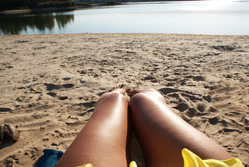Female feet on the sandy beach.