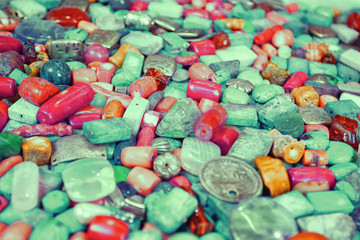 Closeup of colorful mint colored handmade semiprecious beads made of geological minerals and metal. Trendy colored background.