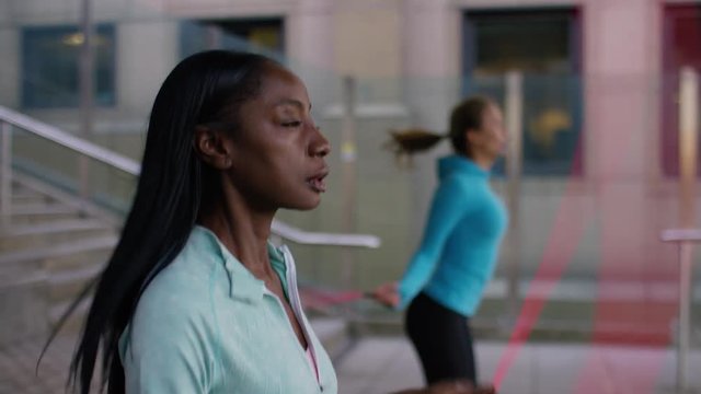 Two healthy fit women skipping with jump ropes, in slow motion