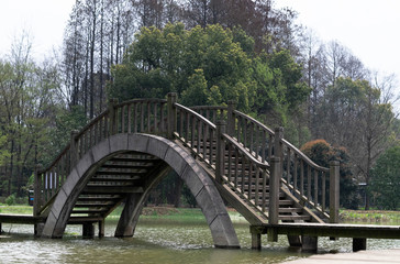 Fototapeta na wymiar Wooden bridge in the park at the part of Wuhan Botanic garden.