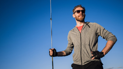Man dressed in casual wear and sunglasses on a yacht. Happy adult bearded yachtsman close-up...
