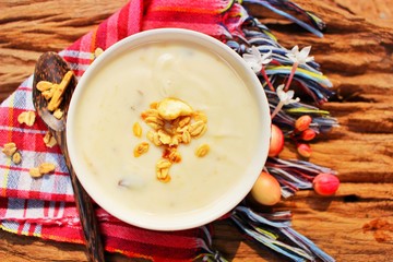 White tofu in a cup on a red cloth and a brown spoon