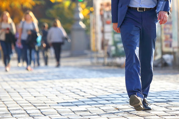 business man crossing the road at a pedestrian crossing on the pavement