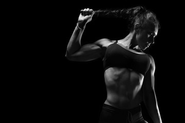 Fit athletic sporty woman posing on black background