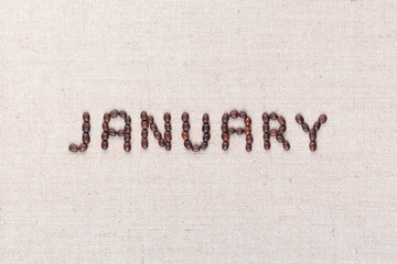 The word January written with coffee beans shot from above, aligned in the center, closeup.