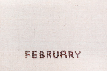 The word February written with coffee beans shot from above, aligned at the bottom.