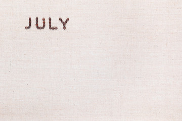 The word July written with coffee beans shot from above, aligned at the top left.
