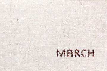 The word March written with coffee beans shot from above, aligned at the bottom right.
