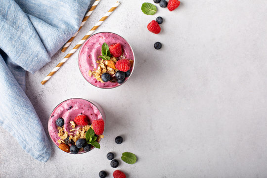 Fresh Mixed Berry Smoothie Topped With Granola Overhead