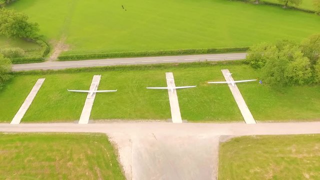 Gliders parked in field by runway