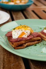 Pancakes or blini with poached egg, smoked ham and cheese sauce for nutritious shrovetide lunch