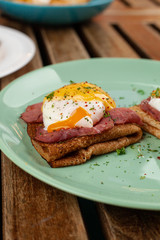 Pancakes or blini with poached egg, smoked ham and cheese sauce for nutritious shrovetide lunch