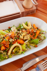 Bowl of vegetarian salad with greens, mini-corn, chickpea and quinoa for dining out in a cafe
