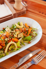 Bowl of vegetarian salad with greens, mini-corn, chickpea and quinoa for dining out in a cafe