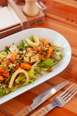 Bowl of vegetarian salad with greens, mini-corn, chickpea and quinoa for dining out in a cafe