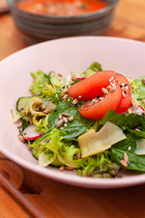 Summer salad with ripe tomatoes, cucumbers, greens and radish for those who keeps a diet