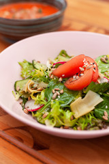 Summer salad with ripe tomatoes, cucumbers, greens and radish for those who keeps a diet