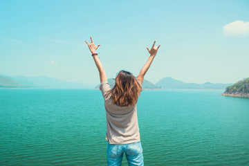 Funny woman standing and hand symbol, love the sky, River and the mountains and enjoy the beautiful nature.
