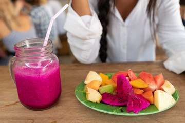 Young girl having a good morning healthy breakfast smoothie drink made of super foods, fruits, nuts, berries
