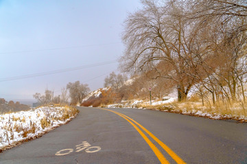 Winter road with bicycle lane sign on the surface