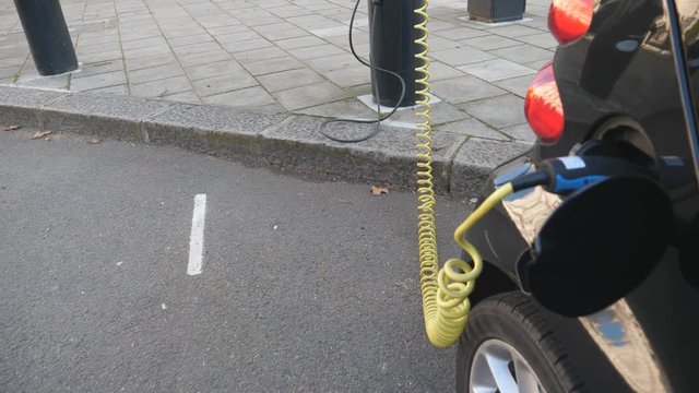 An electric car powering on a charging station.