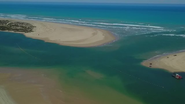 Aerial tracking shot where the Murray River meets the Southern Ocean in Goolwa, South Australia. Dredge can be seen at the Murray Mouth.