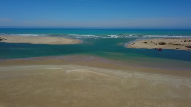 Aerial tracking shot where the Murray River meets the Southern Ocean in Goolwa, South Australia.Dredge can be seen at the Murray Mouth.