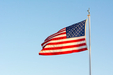 American National Flag Flitting in the Wind on Blue Sky BAckground