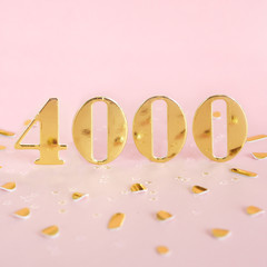 The number 4000 in golden numbers on a pink background and golden confetti. Space for text... - obrazy, fototapety, plakaty
