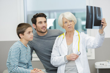 Obraz premium woman doctor with x-ray and patients behind