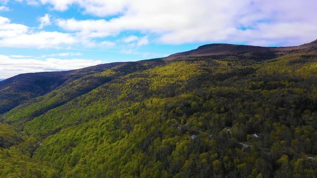 Aerial pan of Adirondack mountains on a partly cloudy day in the spring