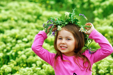 Portrait of a beautiful girl in a wreath of wild flowers