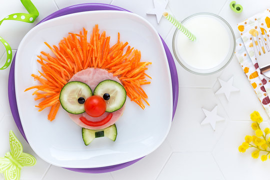 Fun Food For Kids - Cute Smiling Clown Face On Ham Sandwich Decorated With Fresh Cucumber, Carrots And Tomatoes For A Healthy Lunch For Children. Creative Cooking Idea