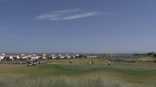 4K 60FPS video of golfers finishing on the 18th hol of a golf course in spain