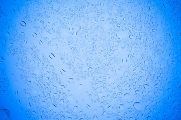 Rain droplets on blue glass background, Water drops on blue glass.