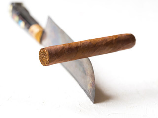 Creative concept of dangers of smoking. Cigar balancing on a knife edge