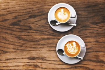 Two cups of coffee on wood table.