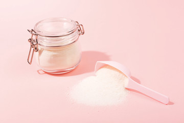 A jar with collagen powder or protein and a scoop.